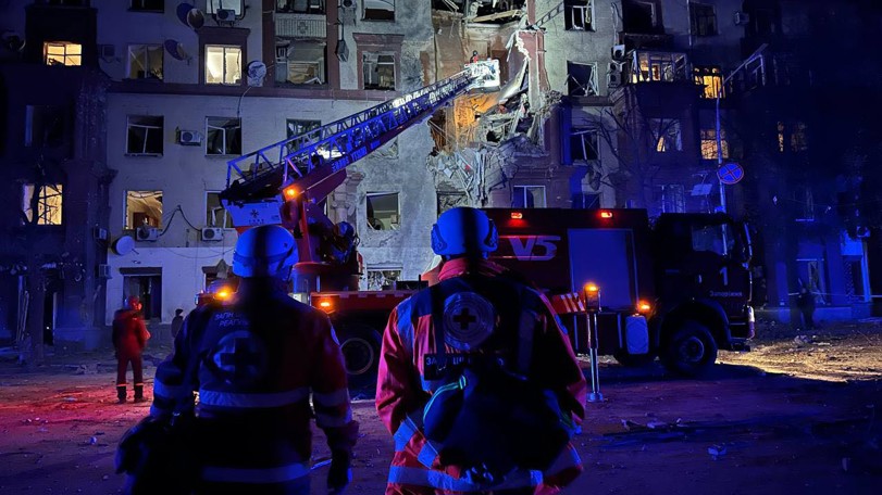 Volontärer hjälper vid beskjuten byggnad.