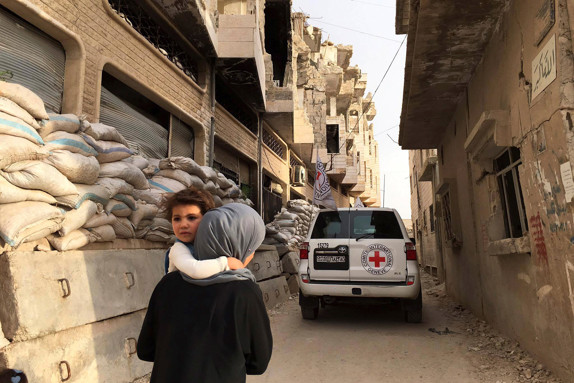 Mor bär barn i krigsdrabbade Syrien.