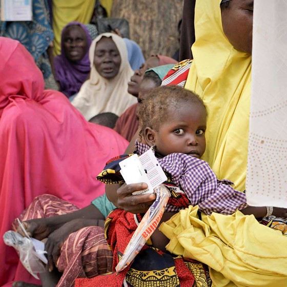 En grupp personer med ett barn i förgrunden.