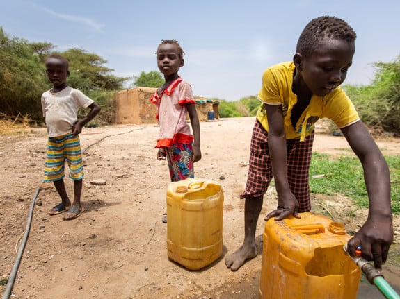 Tre barn hämtar vatten i Sudan, 2021.