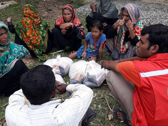 Volontär och kvinnor i Cox's Bazar sitter i cirkel