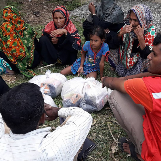 Volontär och kvinnor i Cox's Bazar sitter i cirkel