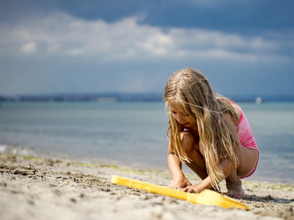 Barn leker på en strand.