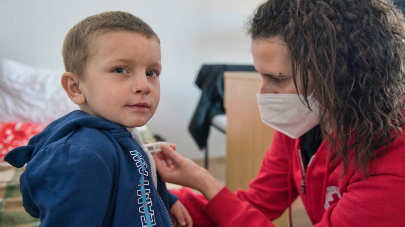 Pojken József får sin temperatur tagen av vår kollega på hjälpcentret i Szeged