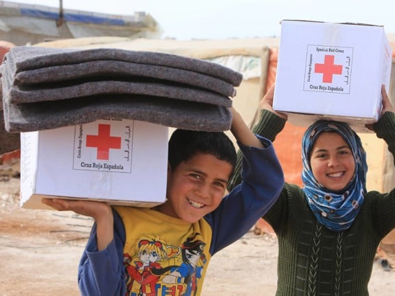 Barn bär på Röda Kors-paket