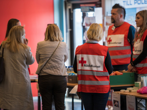 Röda Korset-volontärer tar emot människor som flytt.
