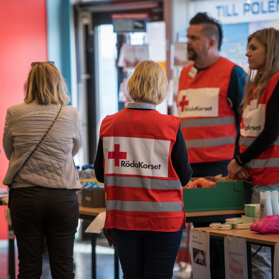 Röda Korset-volontärer tar emot människor som flytt.