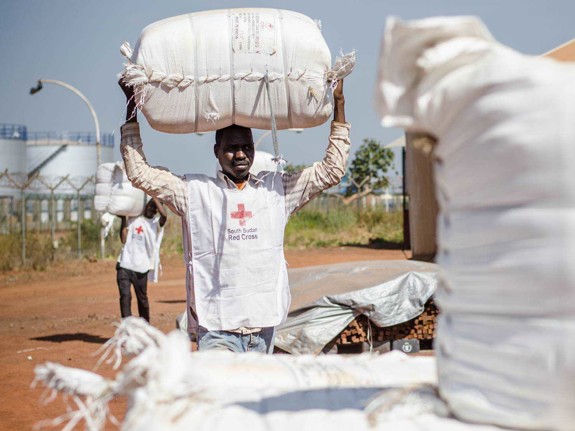 Lokalvolontär bär på vit säck