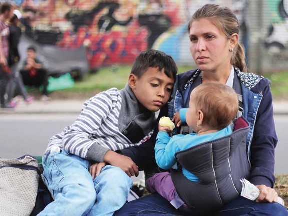 Mamma med barn sitter vid vägkant