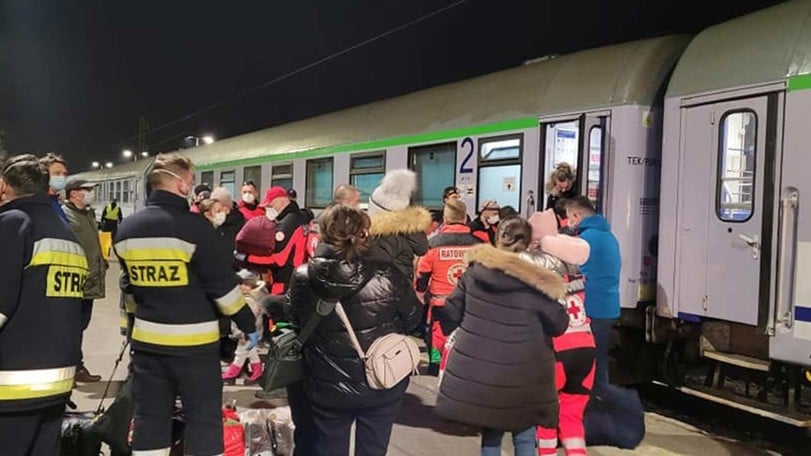 ukrainska barn och volontärer intill tåg