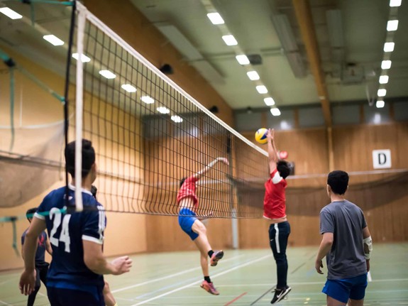 Ensamkommande pojkar spelar volleyboll