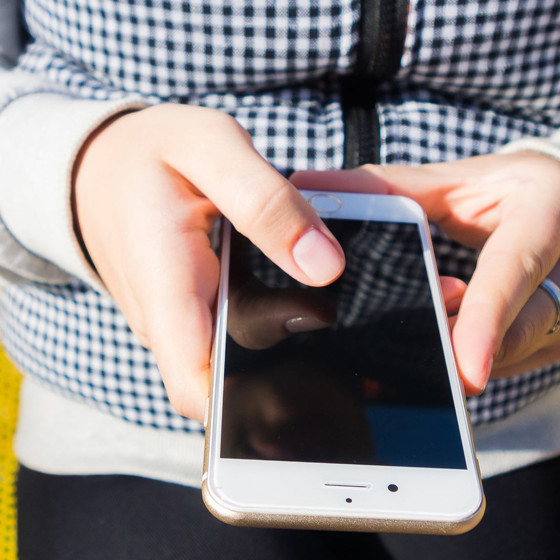 Händer som håller i en mobil