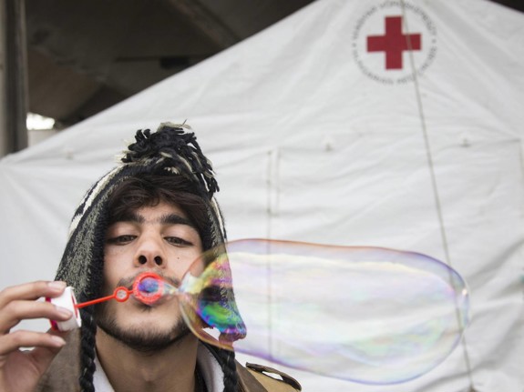 Man klädd i mössa blåser såpbubblor