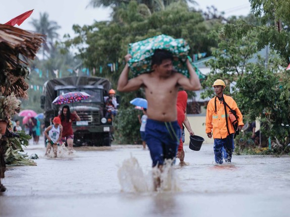 Människor på översvämmad gata efter extremväder