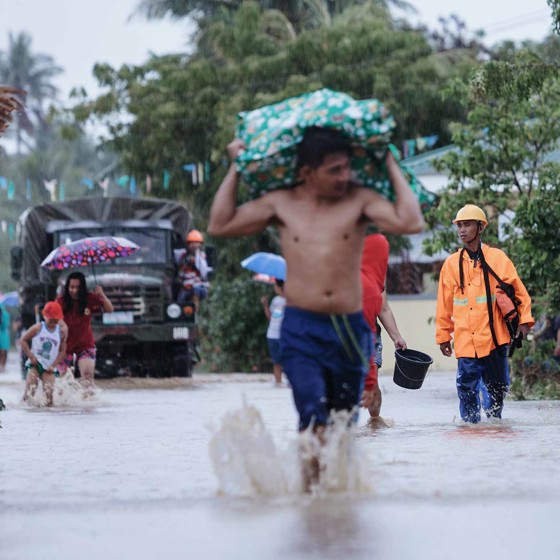 Människor på översvämmad gata efter extremväder