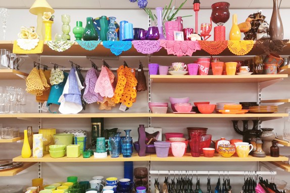 färgglatt-husgeråd-på-hyllor-i-second-hand-butik