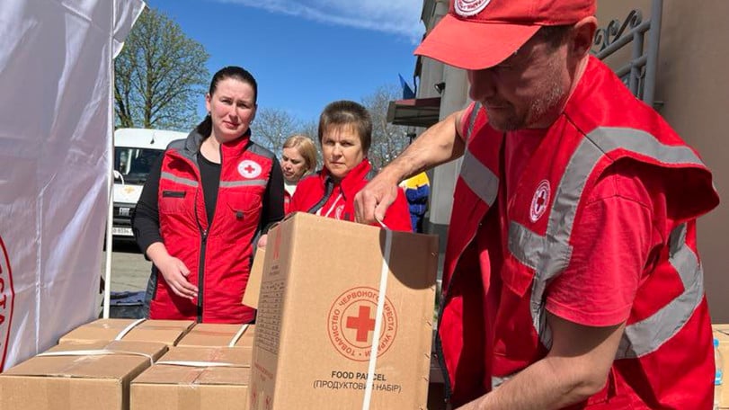 Tre volontärer hjälper till att lasta kartonger med nödhjälp.