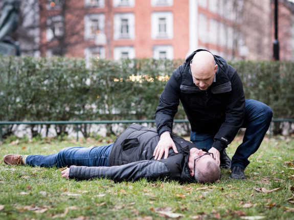 Medvetslös person får hjälp i park