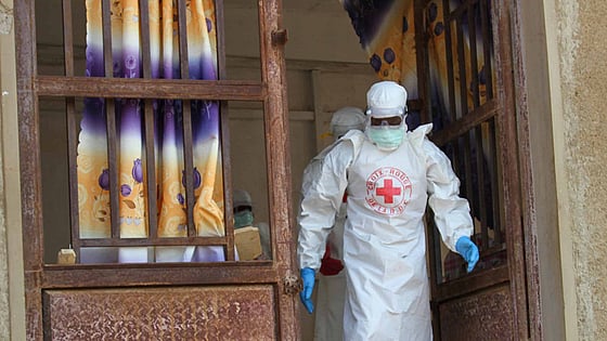Ebolautbrott där vitklädd volontär hjälper.