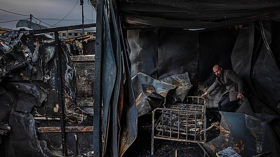 Man står bland bråte i nedbränt hus