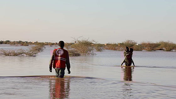 Människor som vadar efter översvämning