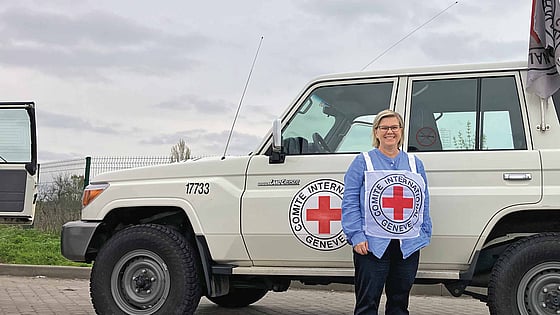 Karin Levenby Bovy framför en bil från Röda Korset.