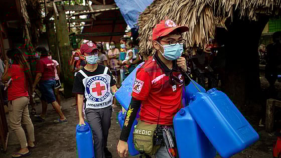 Röda Korset-volontärer med blåa dunkar.