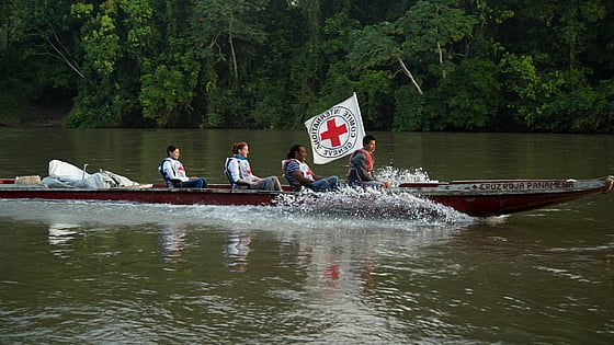 Långsmal båt med Röda Korset-flagga