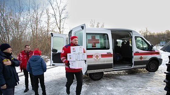 Man drar gummibåt med människor på översvämmad gata