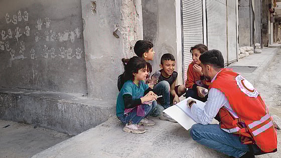 Barn och volontär från Röda Korset i Syrien