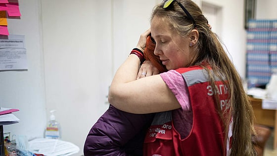 Man drar gummibåt med människor på översvämmad gata