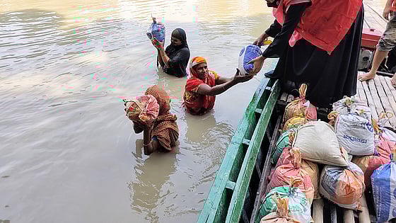 Människor i översvämning får hjälp via båt.