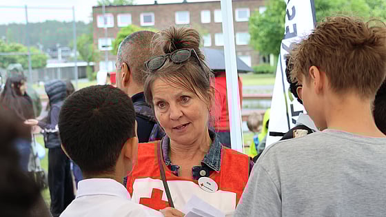 En person som pratar med två barn