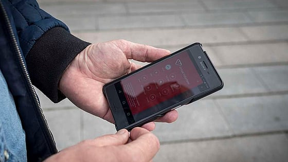 Hand håller i mobiltelefon