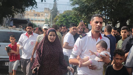 Volontär bär barn i Gaza