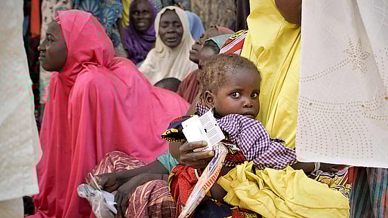 En grupp personer med ett barn i förgrunden.