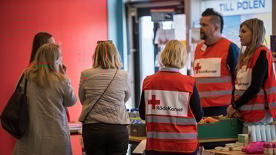 Röda Korset-volontärer tar emot människor som flytt.