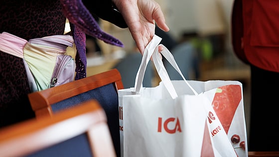 Hand som håller i ICA-kasse.