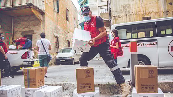 Män lastar av hjälppaket från helikopter