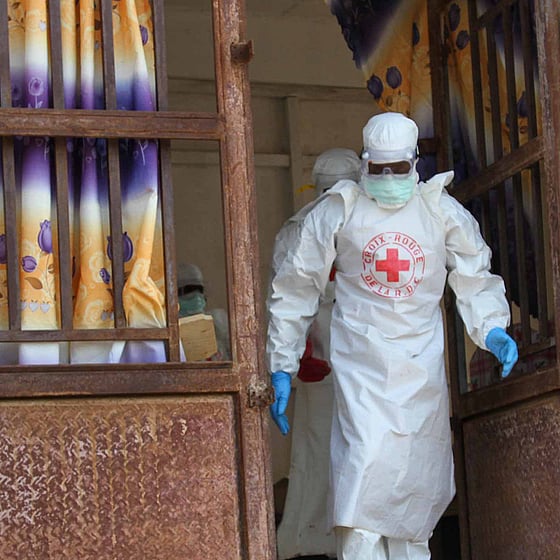 Ebolautbrott där vitklädd volontär hjälper.