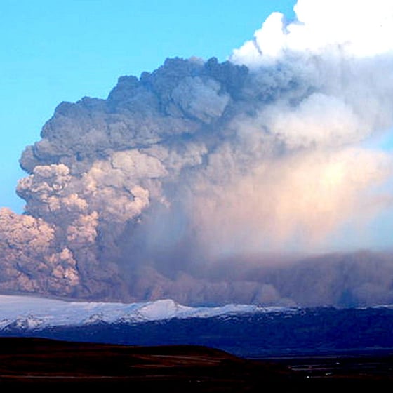 Askmoln mot blå himmel efter vulkanutbrott