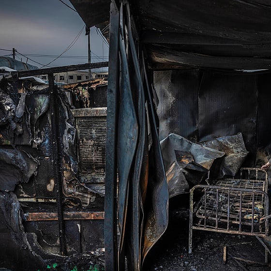 Man står bland bråte i nedbränt hus