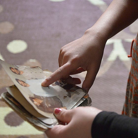 En hand pekar på fotografi av saknade familjemedlemmar.