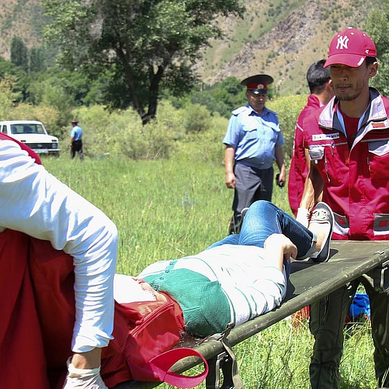 En man bärs på bår av Röda Korsets volontärer.