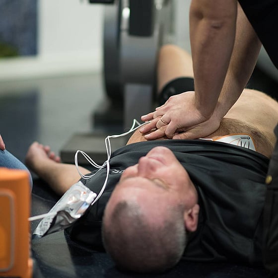 Man har fått hjärtstopp och får hjälp med hjärtlungräddning, HLR, med hjärtstartare