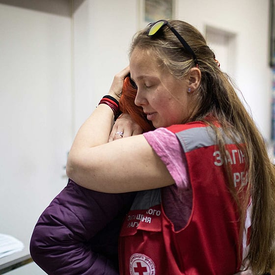 Man drar gummibåt med människor på översvämmad gata