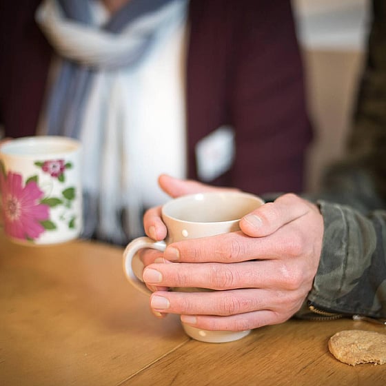 Händer och kaffemugg.