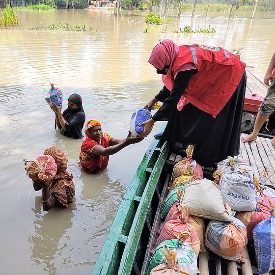 Människor i översvämning får hjälp via båt.