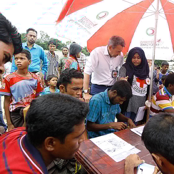 Vuxna och barn står under parasoll