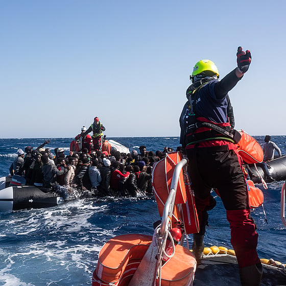 Röda Korset volontärer hjälper människor i gummiflotte